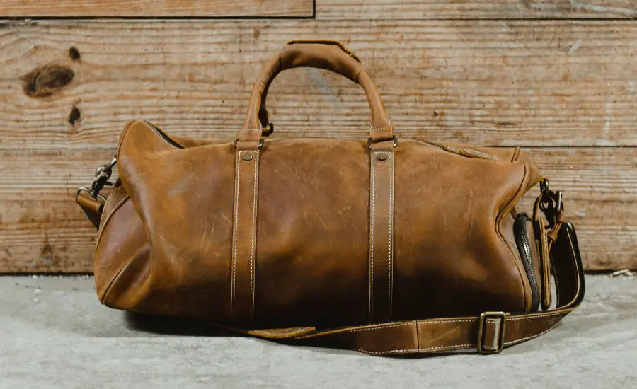 a brown leather bag on a wooden surface