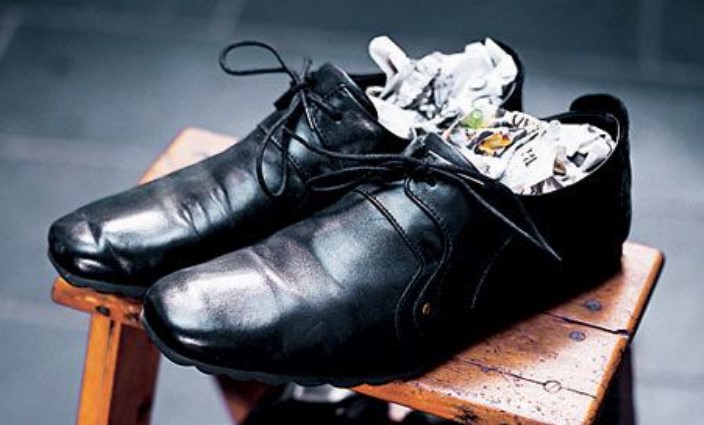 Stretching leather shoes with newspaper